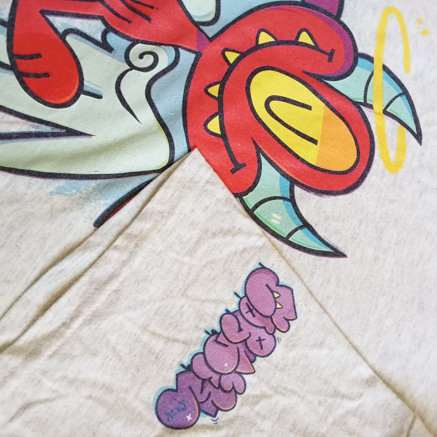 devil CORKiE character Diablo as an angel with the bubble letters 'throwie' on the sleeve. On a shirt by CORKiE, an indie streetwear brand based off of graffiti artwork.
