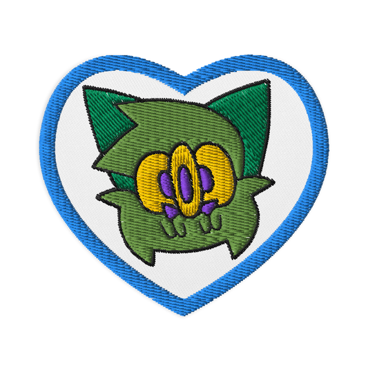 embroidered patch of a green furry monster character by Brighton street artist CORKiE