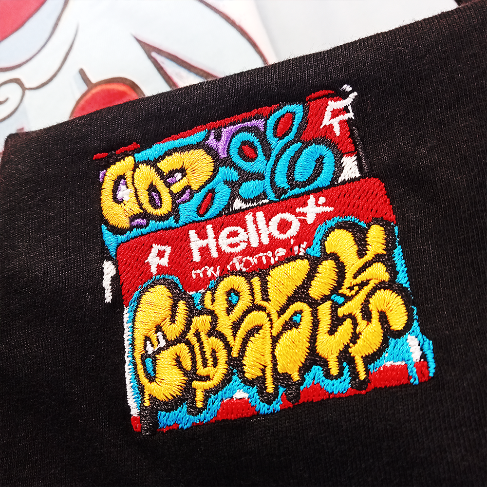 'Hello my name is' graffiti sticker embroidery pattern, on a shirt by indie streetwear brand CORKiE, based in Brighton.