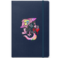 A navy blue notebook with a pink furry character on the front